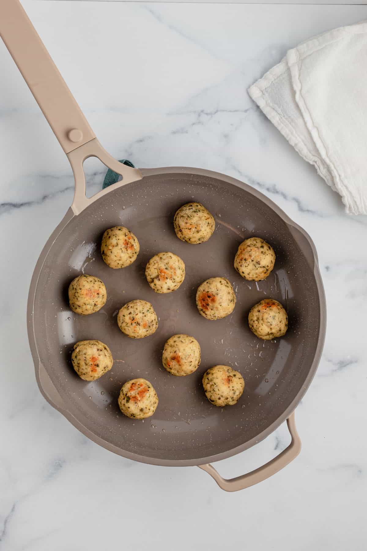 Cooked chicken meatballs in a skillet.
