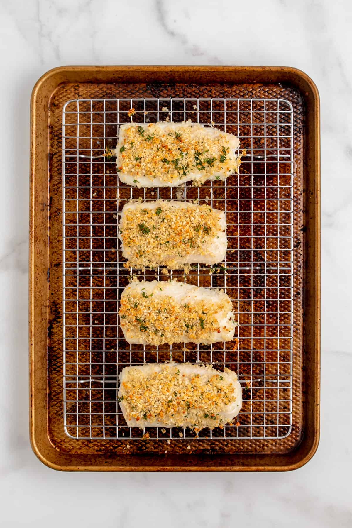 Baked panko crusted cod fillets on a baking sheet.