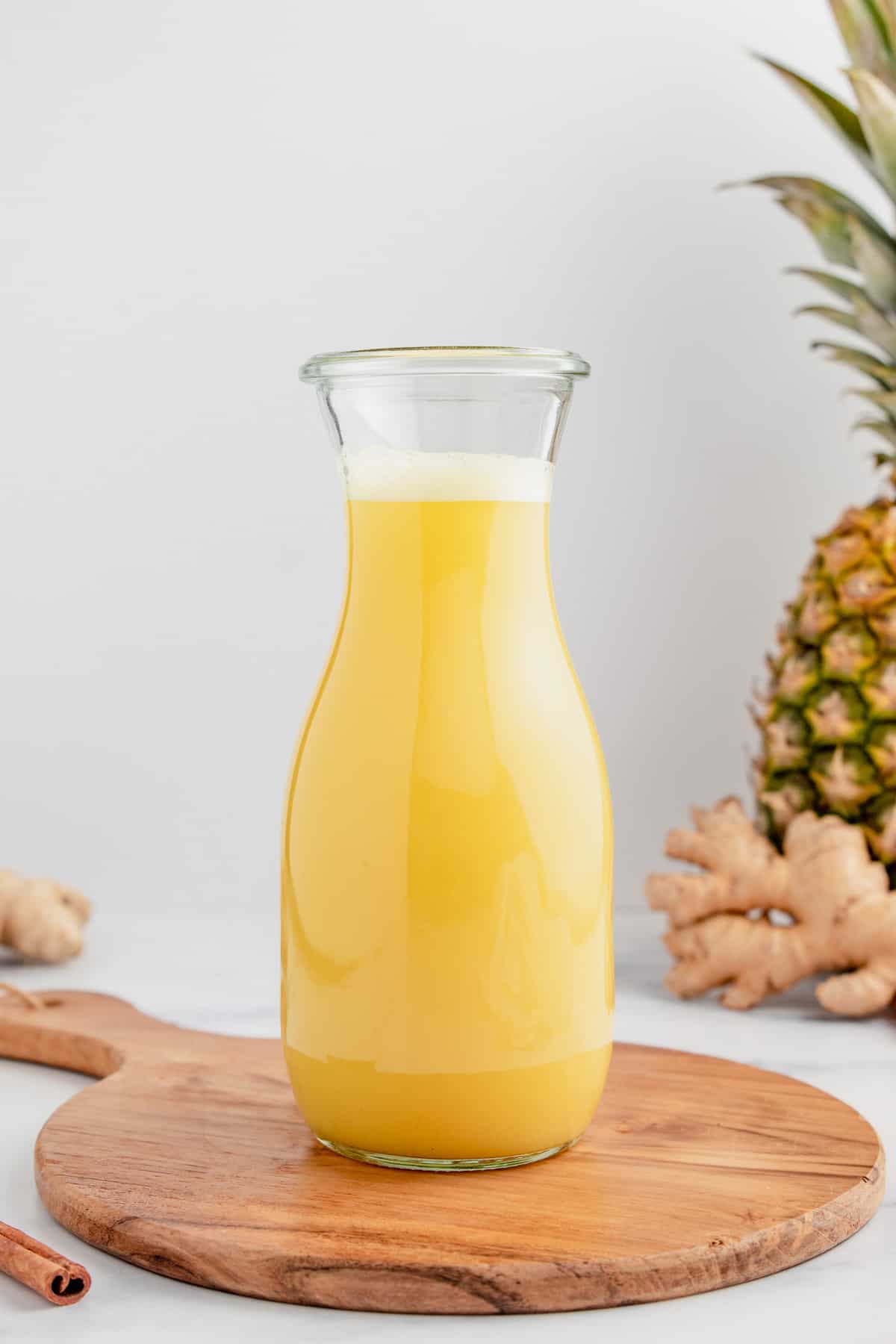 A glass bottle full of pineapple ginger juice.