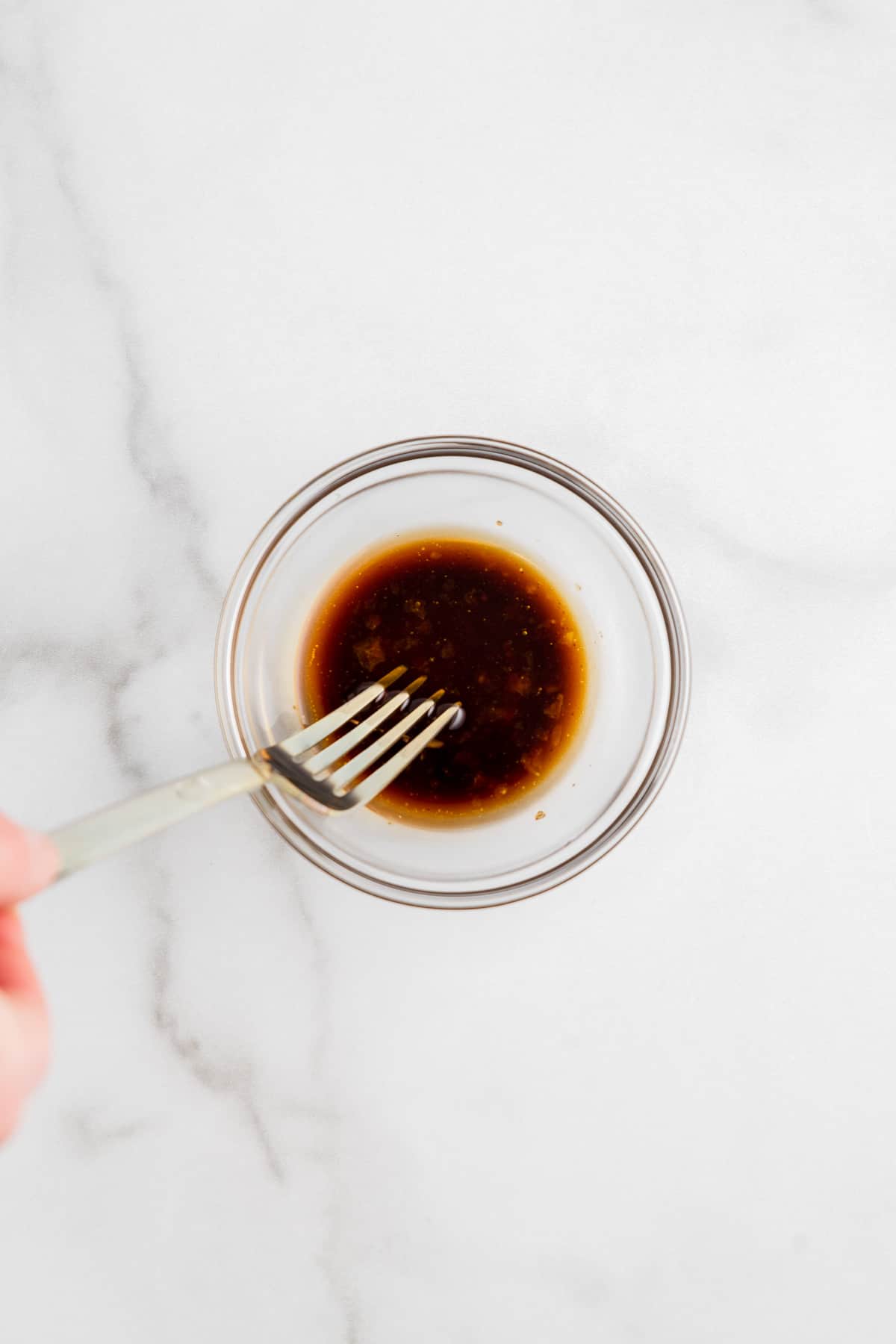 Mixing balsamic vinaigrette in a small bowl.