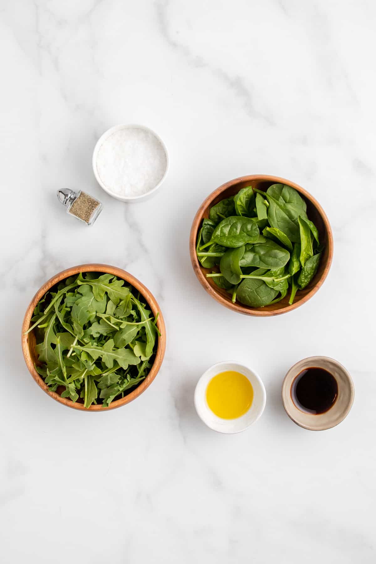 Ingredients needed to make a spinach and arugula salad.