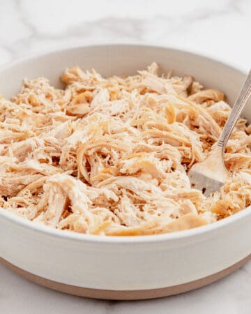 Shredded chicken in a bowl with a fork.