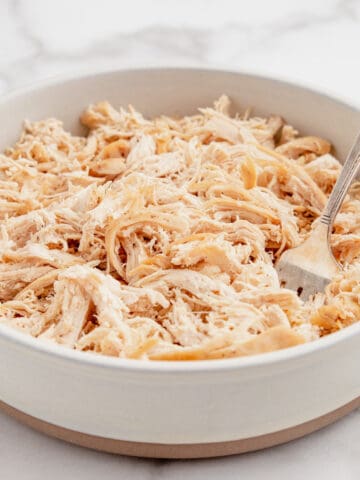 Shredded chicken in a bowl with a fork.