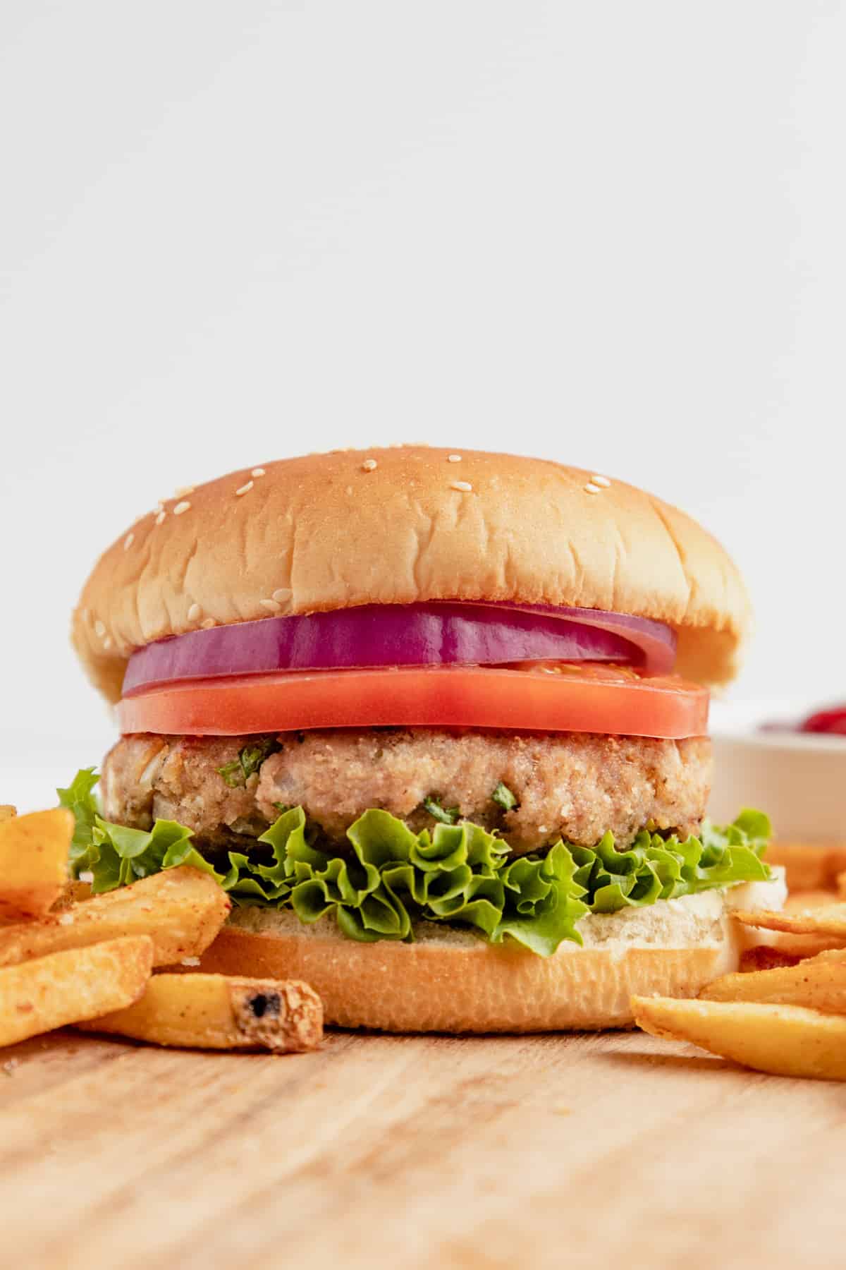 Gluten free turkey burger with lettuce, tomato, and onion served with fries.