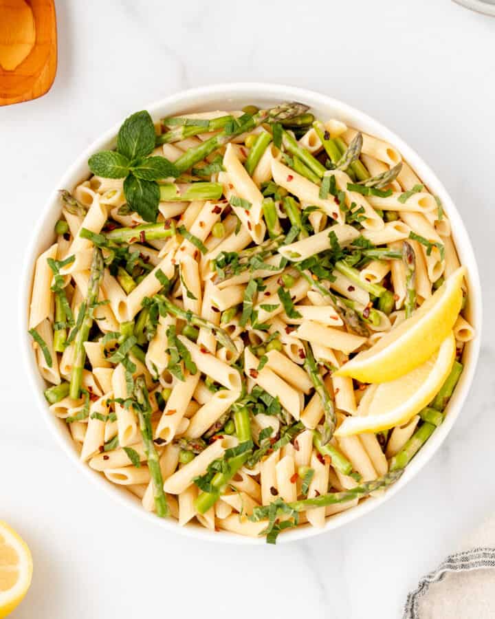 A bowl of spring vegetable pasta with lemon and butter sauce.