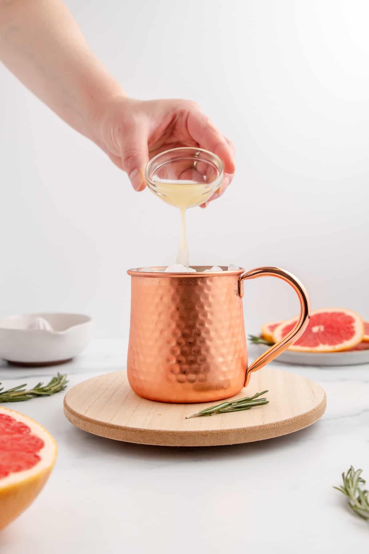 Pouring fresh lime juice into a copper mug to make a Moscow Mule.