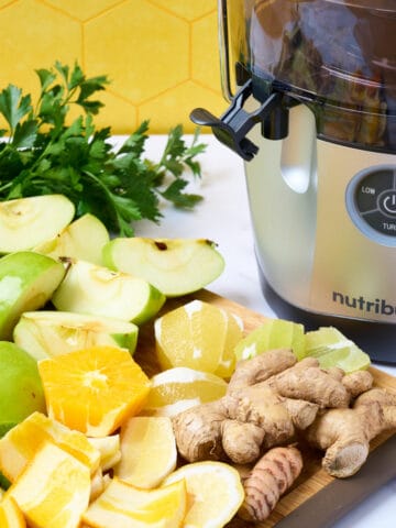 A featured image of a Nutribullet juicer with prepped ingredients on cutting board to the side.