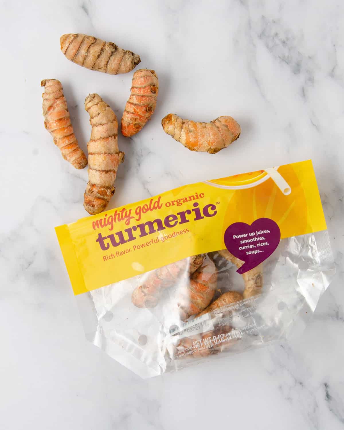 A bag of turmeric root on a marble countertop.