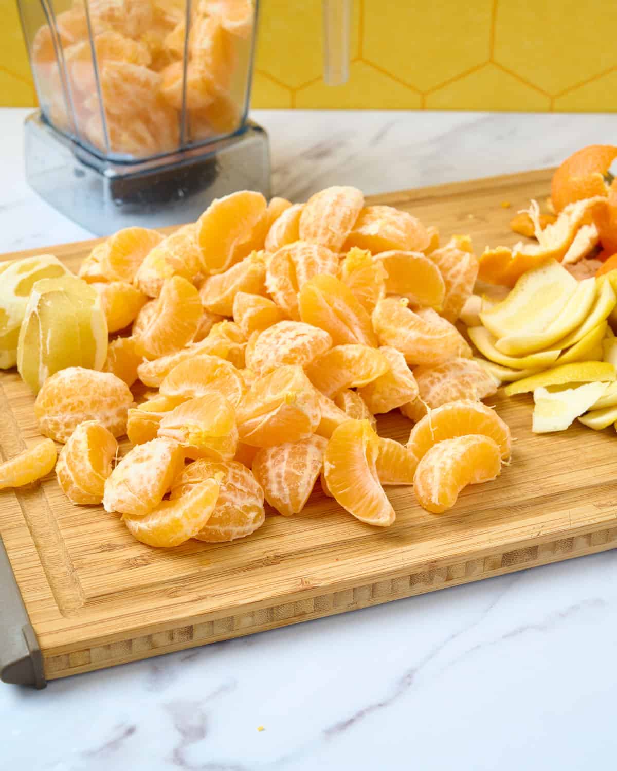 Peeled mandarins and lemons on a cutting board.