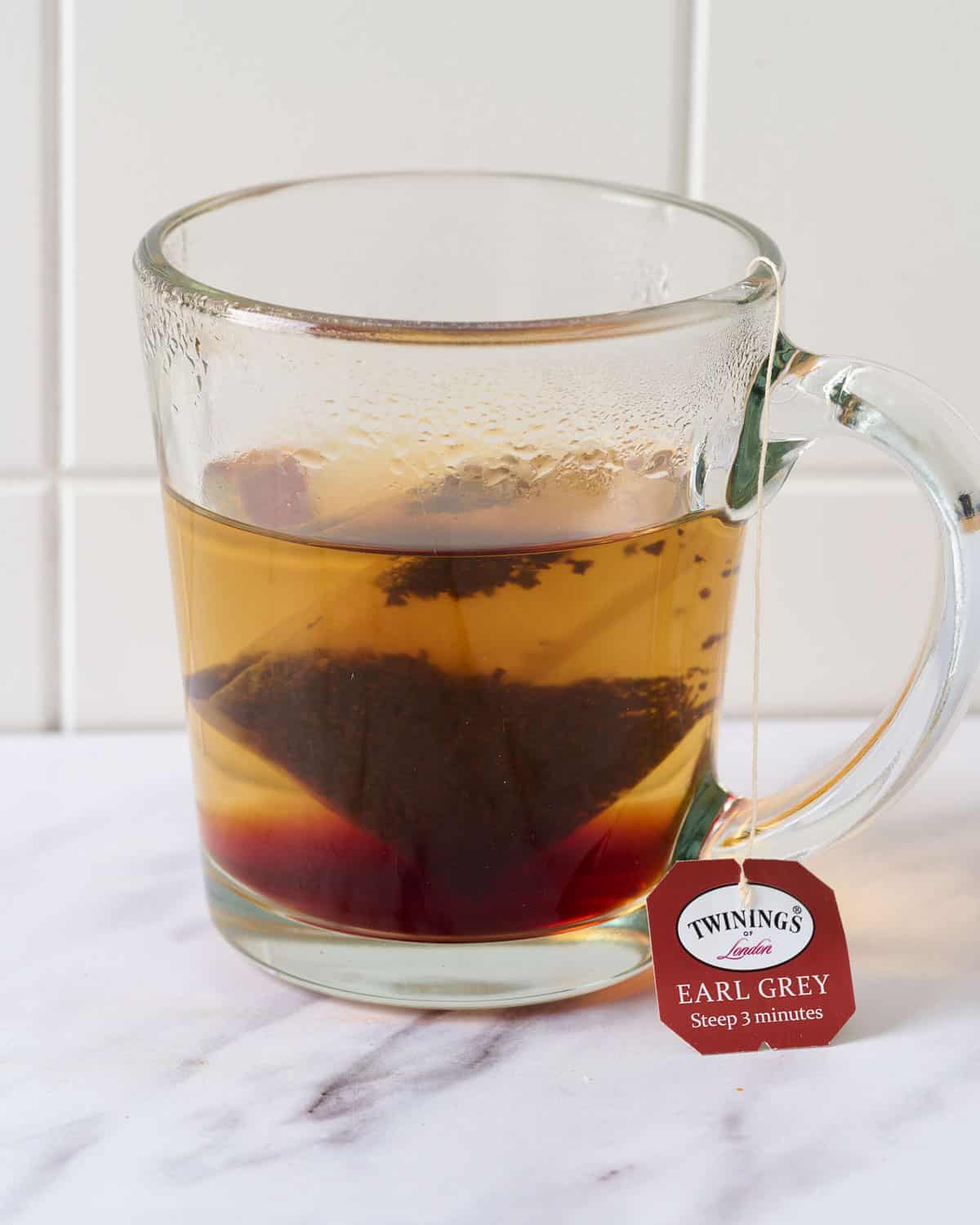 Earl grey tea steeping into boiling water in a mug.
