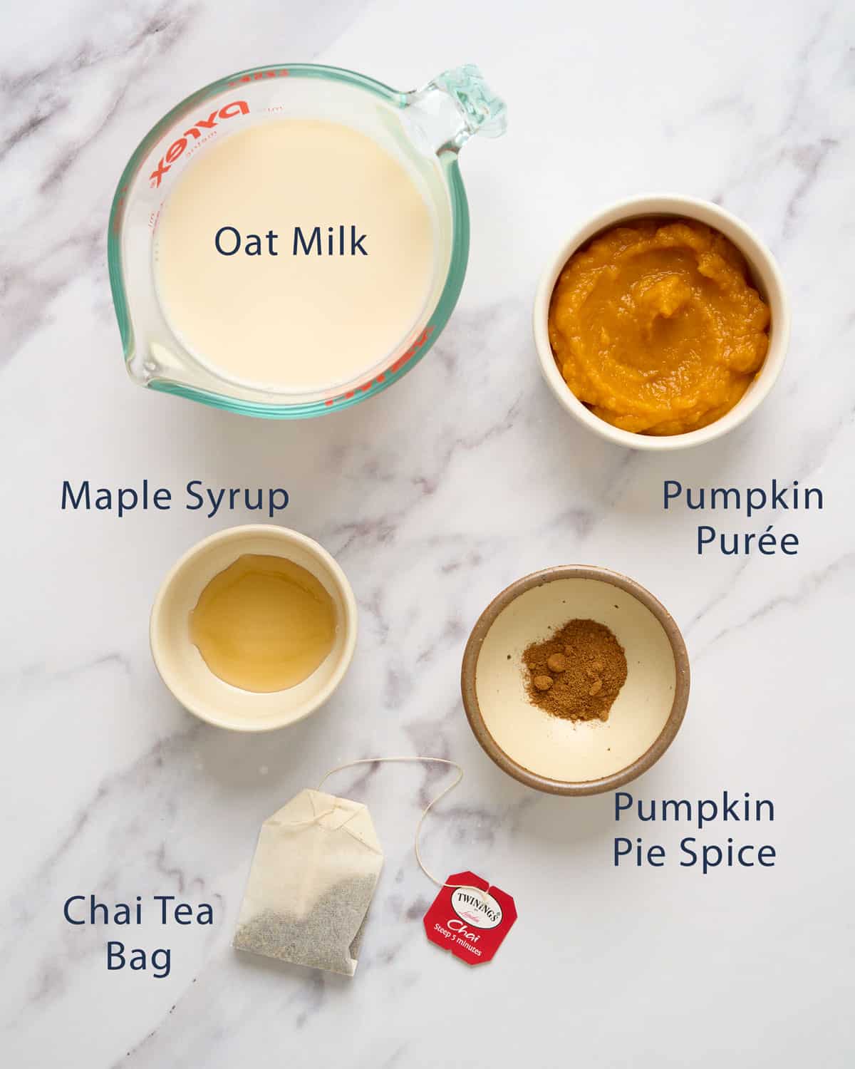 The ingredients for a Starbuck's copycat pumpkin chai latte on a marble table.