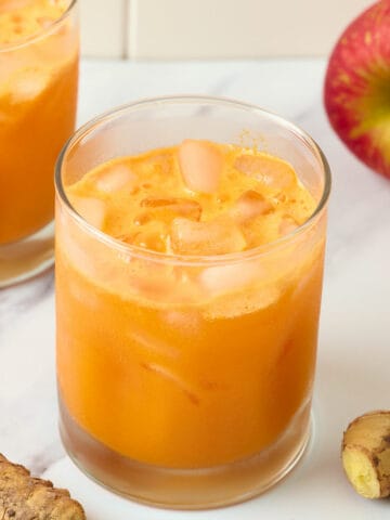A cold glass of carrot ginger turmeric juice.