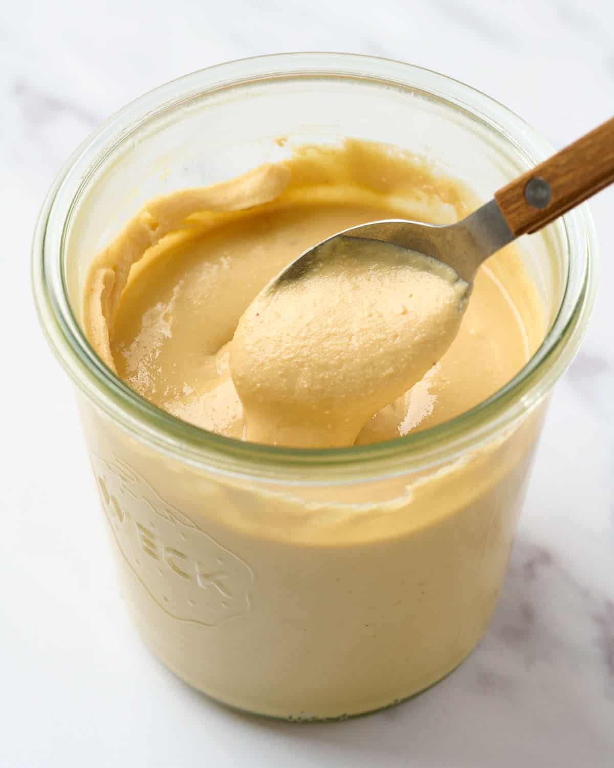 A jar of cashew butter with a spoon inside.