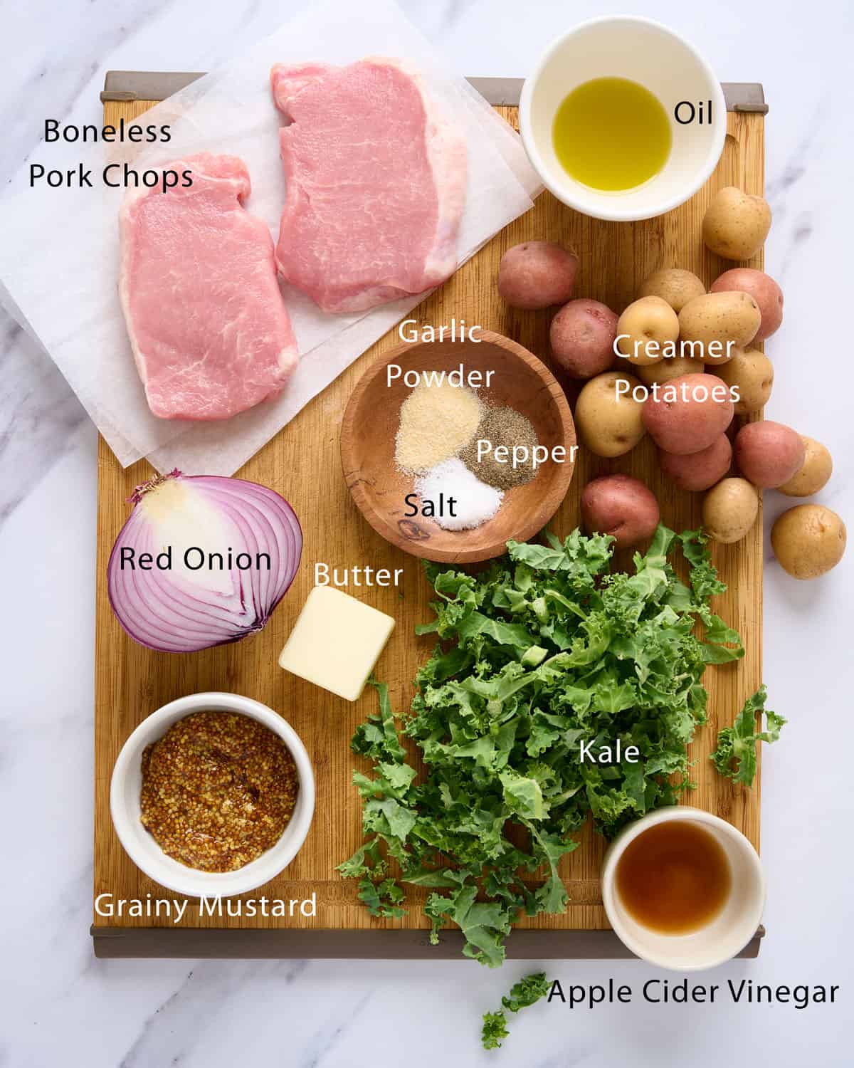 Ingredients needed to make dutch oven pork chops with potatoes and kale.