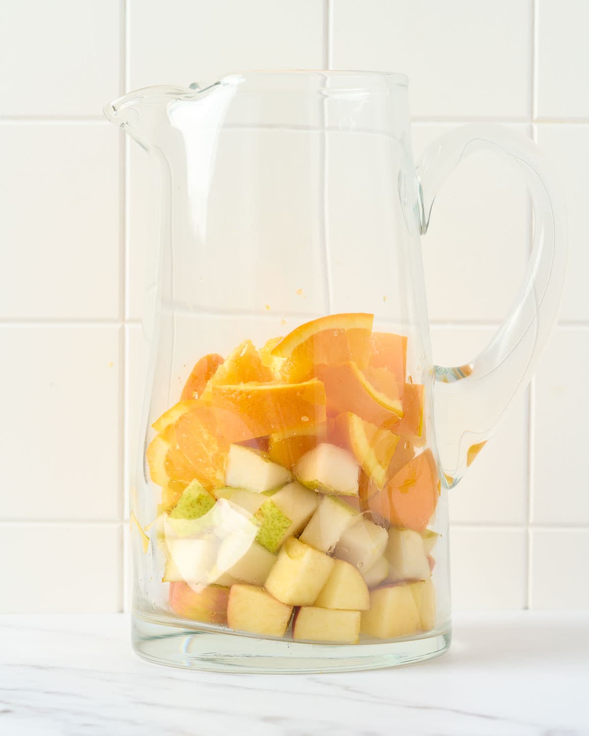 Fall fruit in a pitcher for making white sangria.