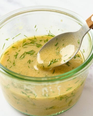 Creamy dill mustard dressing in a small bowl with a spoon.