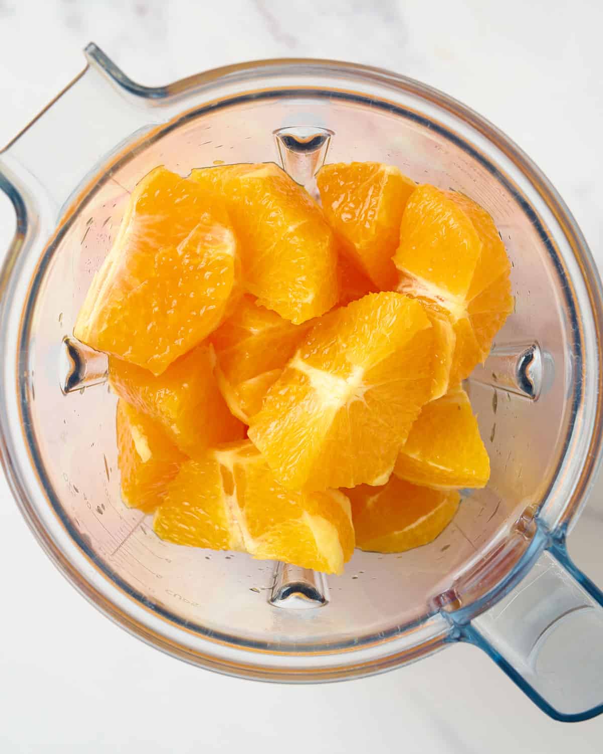 https://elisetriestocook.com/wp-content/uploads/2023/10/orange-wedges-in-the-blender-for-fresh-orange-juice.jpg