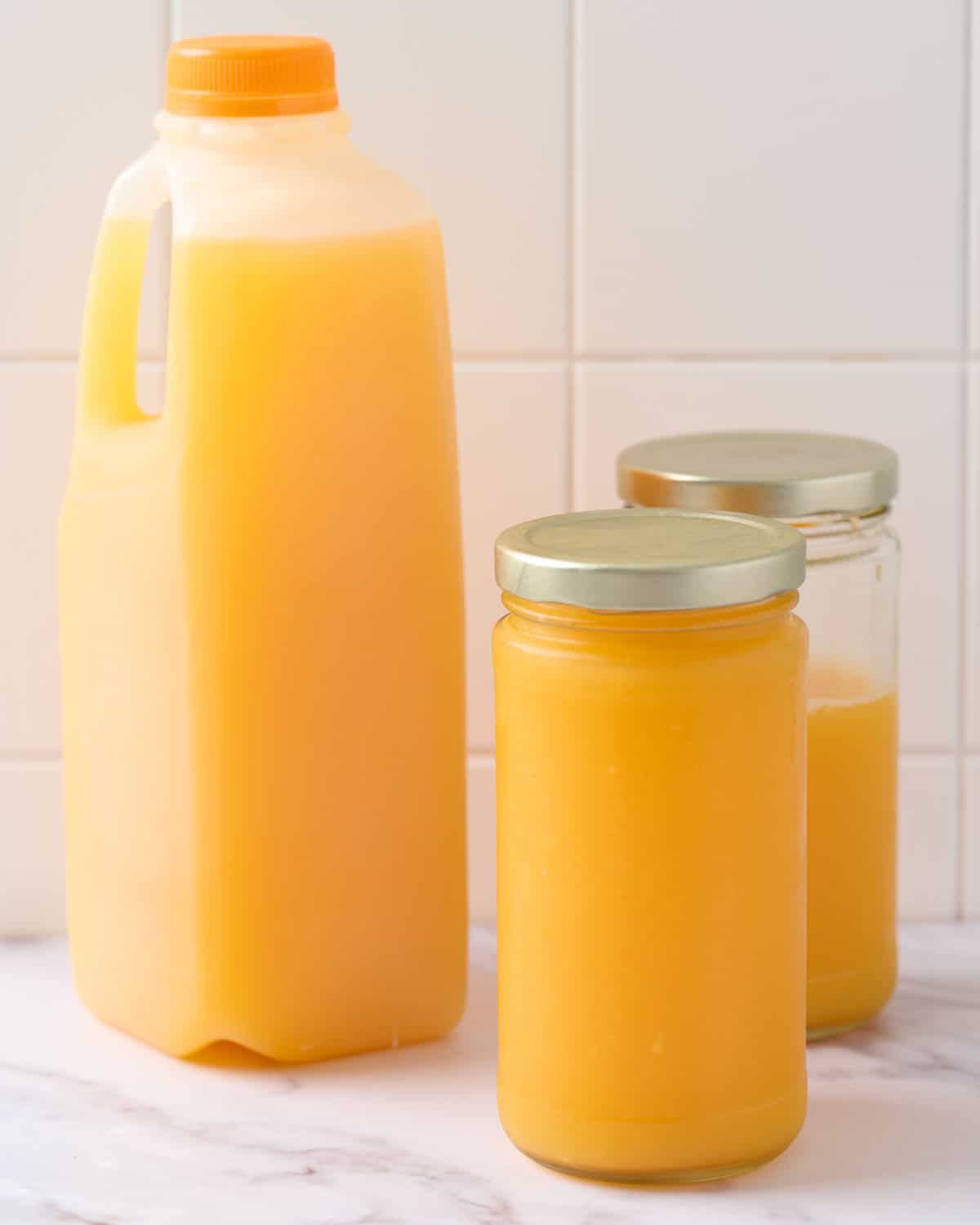 Store bought versus homemade orange juice on a countertop.