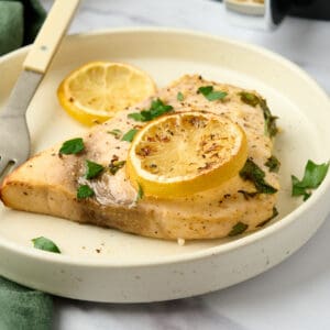 Air fryer swordfish topped with lemon and parsley.
